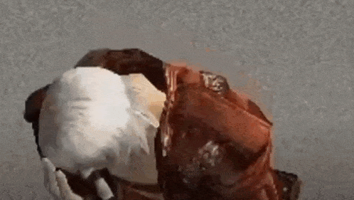 a man in a red jacket is kneeling down and covering his face .