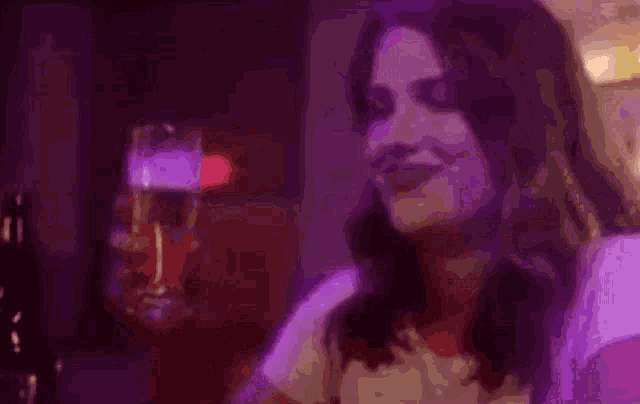a woman is smiling in a purple light
