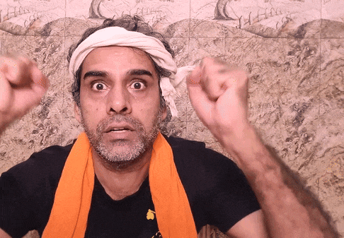 a man with a bandage on his head and an orange scarf around his neck is making a funny face