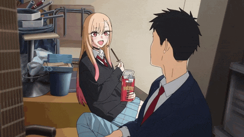a girl sitting next to a man holding a box of pocky sticks