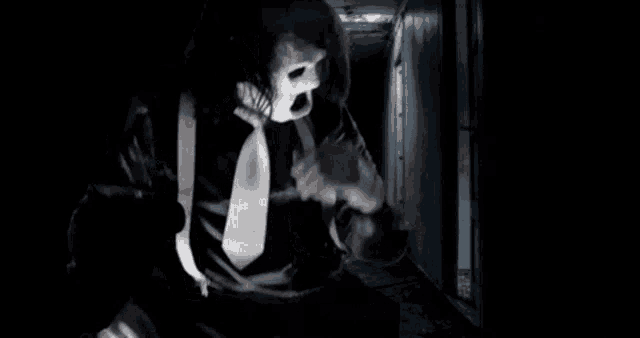 a man in a mask and tie is walking down a hallway