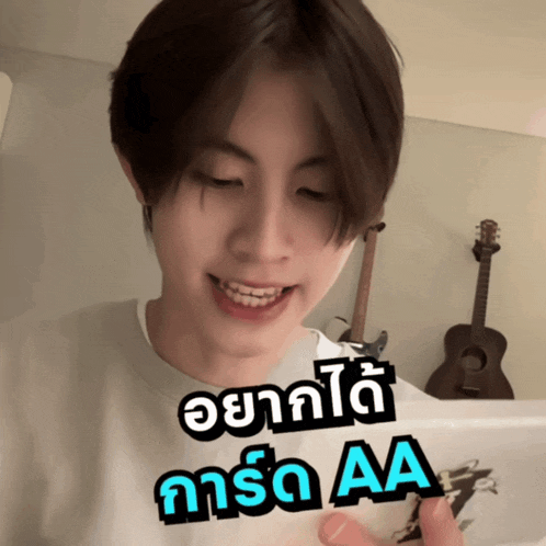 a young man with braces on his teeth is smiling and holding a cell phone with aa written on it