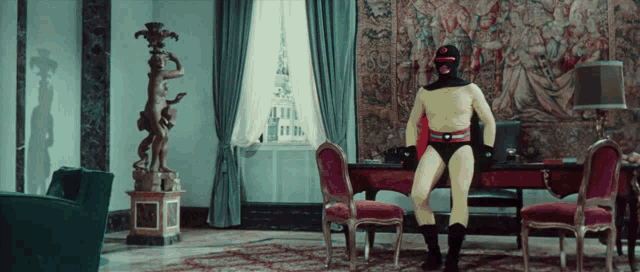 a man in a yellow superhero costume is standing in a room