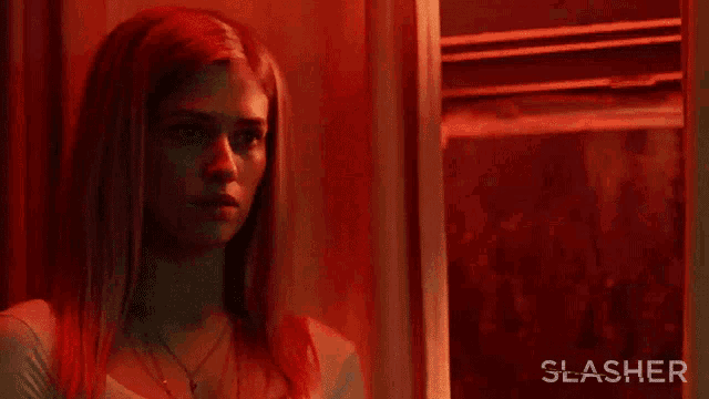 a poster for a movie called slasher shows a woman looking out a window