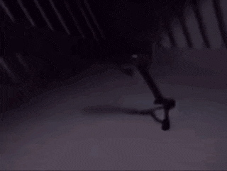 a person is standing in a dark room with a shadow of a person on the floor .