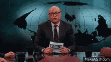 a man in a suit and tie is holding a paper that says nightly
