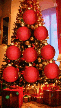 a christmas tree decorated with red and gold ornaments and gifts