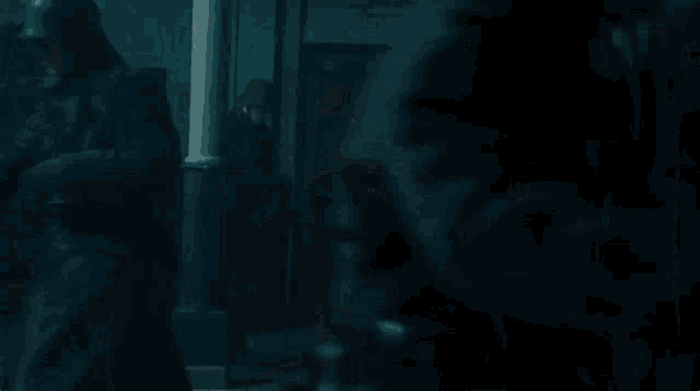 a woman in a wonder woman costume is holding a sword and shield in a dark room .