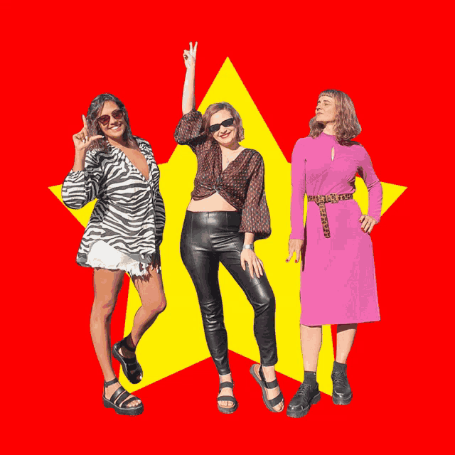 three women are standing in front of a yellow star and one is giving a peace sign