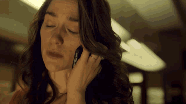 a woman with a ring on her finger is talking on a phone