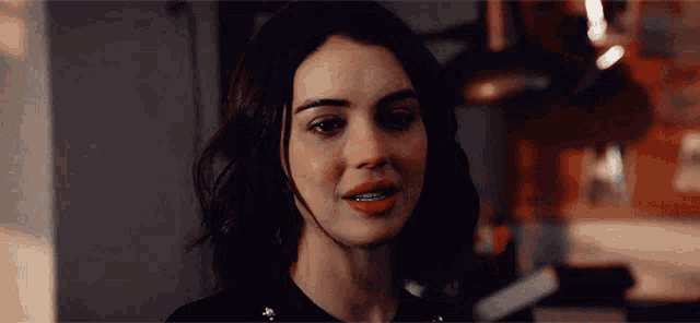 a close up of a woman 's face with a slight smile on her face