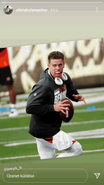 a man wearing headphones holds a football with the word bengal on his shirt