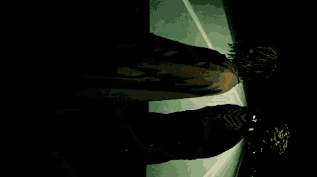 a woman in a trench coat is standing in a dark room