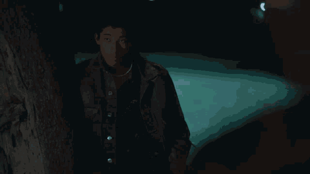 a man leaning against a tree in the dark