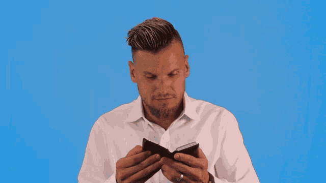a man in a white shirt is holding a black wallet