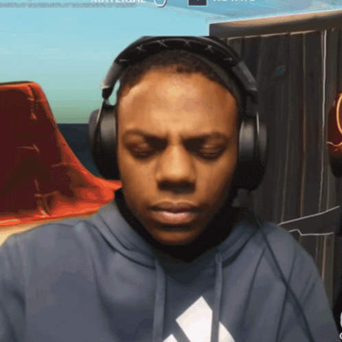 a man wearing headphones and a hoodie with an adidas logo on it