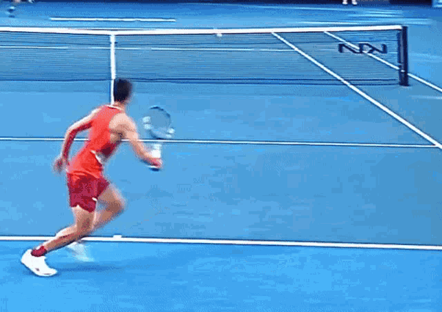 a tennis player is sitting on the court with his legs crossed and a racket in his hand .