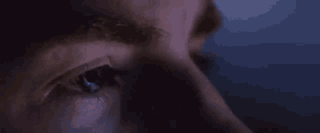 a close up of a man 's eye in the dark