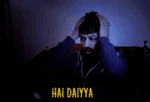 a man with a beard is sitting on a bed with his hands on his head and the words hai dairya written on the bottom