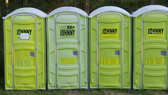 a row of johnny portable toilets are lined up
