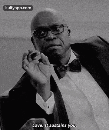 a man in a suit and bow tie is smoking a cigar and saying `` love : it sustains you '' .