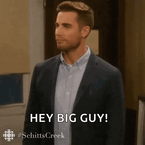 a man in a suit and blue shirt is saying hey big guy .