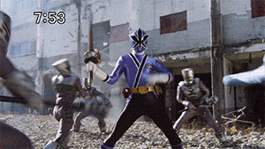 a group of people are fighting in front of a building that says 7:53 on it