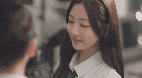 a woman in a white shirt and black tie looks at another woman