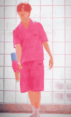 a man in a pink shirt and pink shorts is standing in front of a glass wall