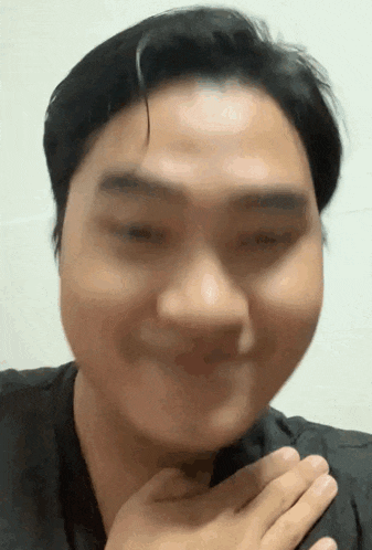 a close up of a man 's face with a hand on his chest