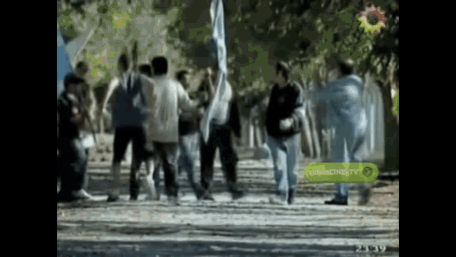 a group of people are dancing in front of a videocineg tv sign