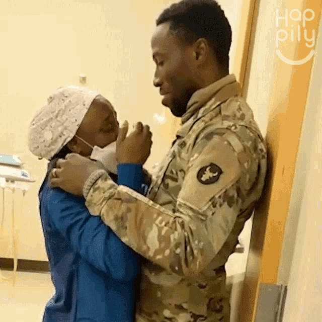 a man in a military uniform is hugging a nurse in a hospital
