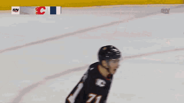 a hockey player wearing a black jersey with the number 11 on it