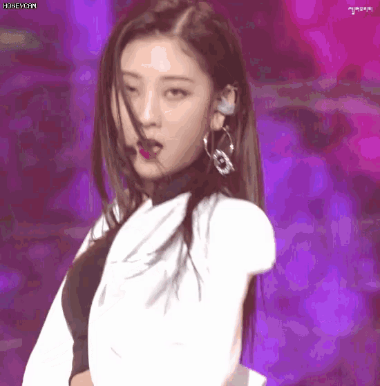 a woman with a microphone on her ear is dancing on a stage with the words honeycam in the corner