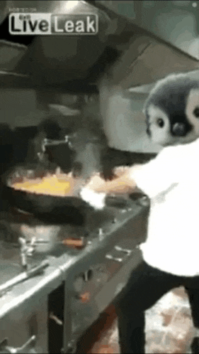 a person is cooking in a kitchen with a penguin mask on their face