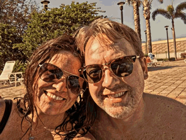 a man and a woman wearing sunglasses are posing for a photo