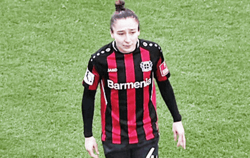 a female soccer player wearing a red and black striped shirt with barmenia on it