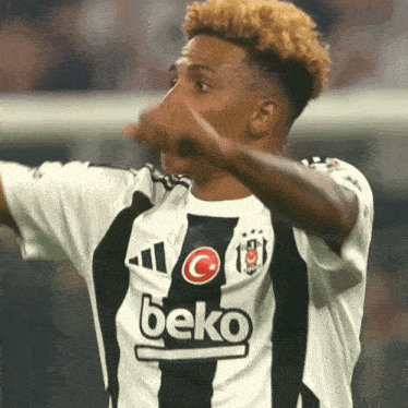 a soccer player wearing a black and white jersey that says beko on it
