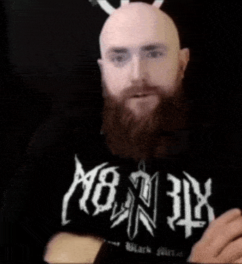 a bald man with a beard is wearing a black shirt that says monnik