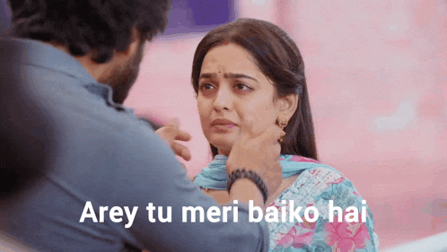 a man is touching a woman 's face with the words " arey tu meri baiko hai " above them