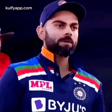 a man with a beard and a hat is wearing a blue shirt with a mpl logo on it .