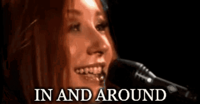 a woman is smiling in front of a microphone with the words in and around above her