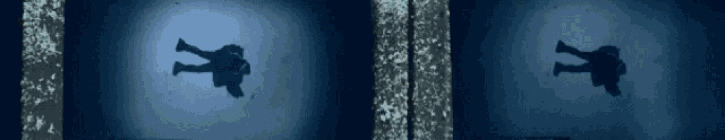 a person 's shadow is cast on a blue wall