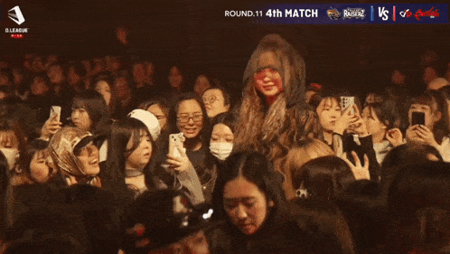 a crowd of people are watching a match between tsumu and d league