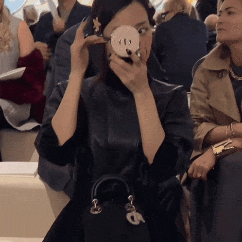a woman taking a picture of herself in a mirror with the letter d on her face