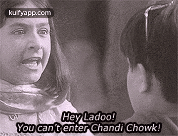 a black and white photo of a girl and a boy talking to each other in a movie .