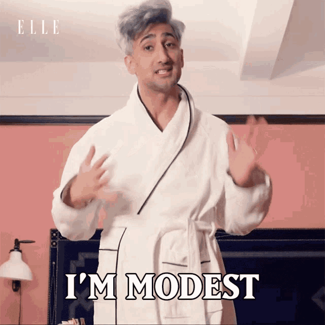 a man in a bathrobe is saying i 'm modest