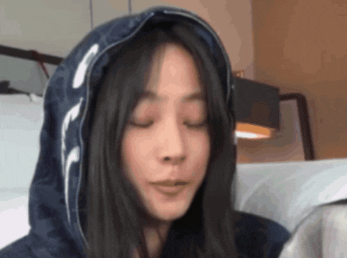 a woman wearing a blue hoodie with a white letter f on it