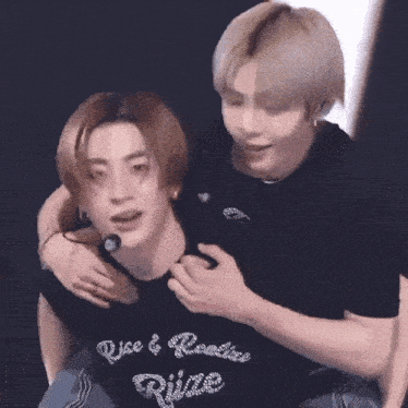 two men are hugging each other and one of them is wearing a shirt that says we & realine wings