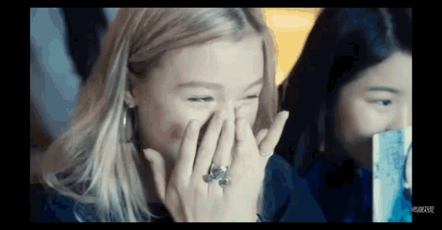a woman with a ring on her finger is covering her mouth